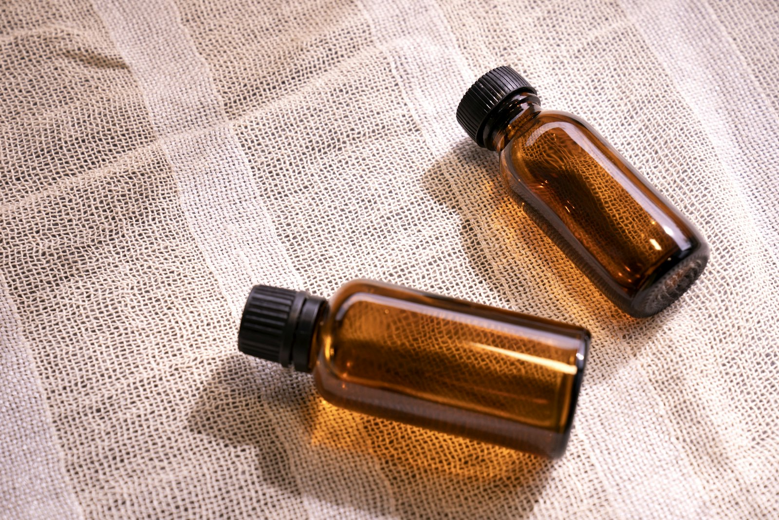 Two empty amber glass bottles on a linen cloth