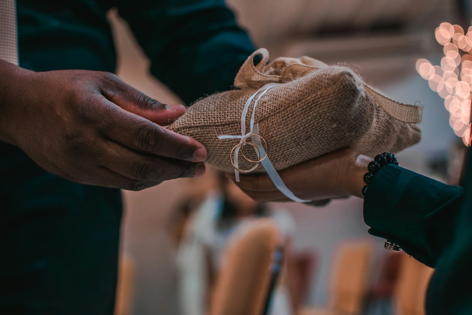One person handing a small wrapped parcel to another